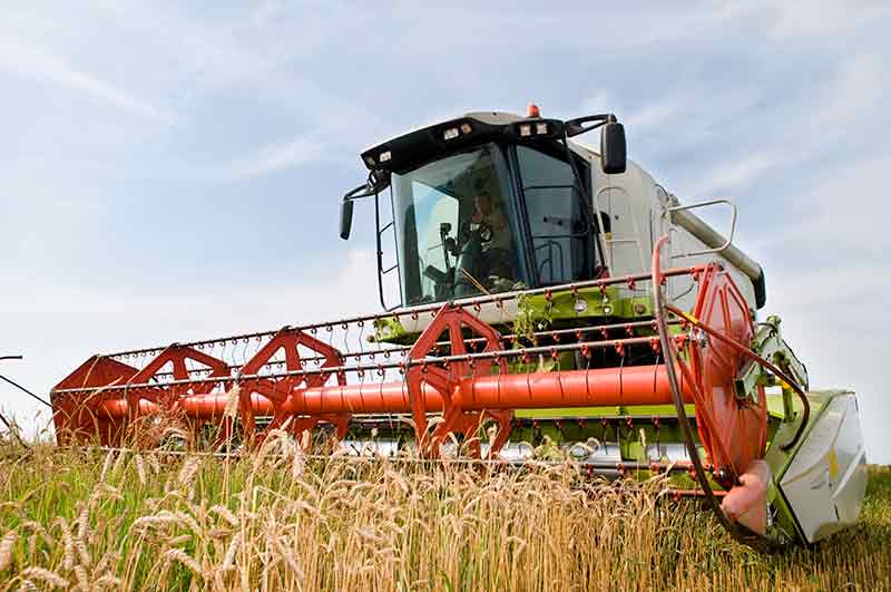 Photo of Agricultural equipment harvesting crops.