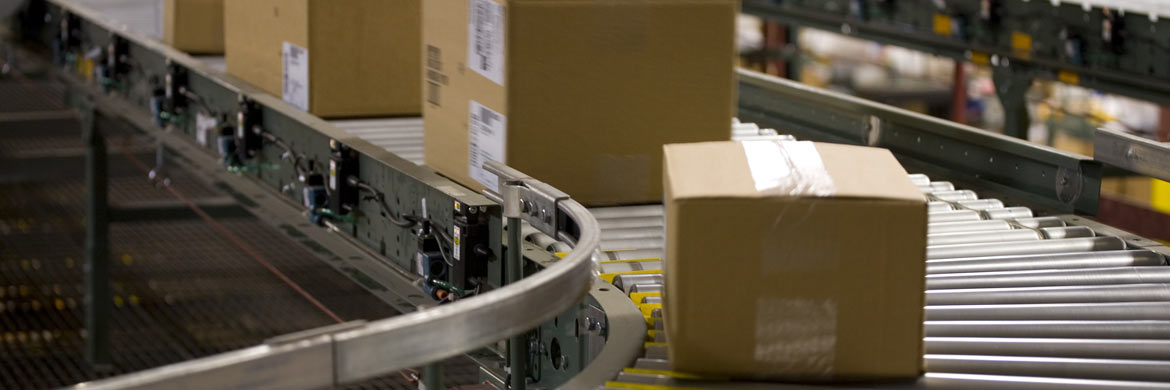 Four boxes of varying sizes on a conveyor belt.