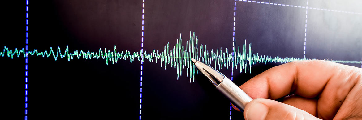 Hand pointing to graph of vibration waves.