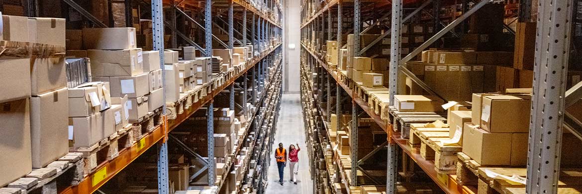 Overhead shot of warehouse with filled shelves and two people walking.