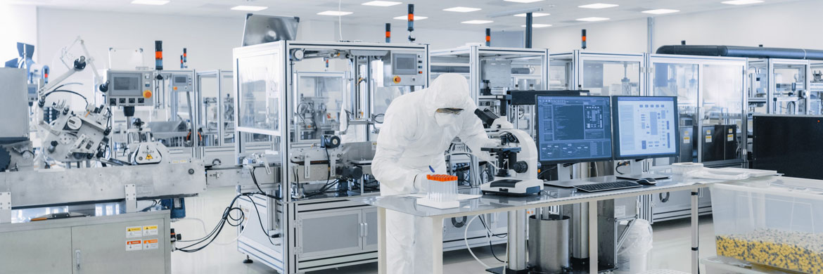 Technician writing notes in pharmaceutical lab.