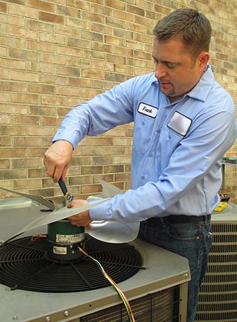 Photo of technician working on outdoor AC Unit motor.
