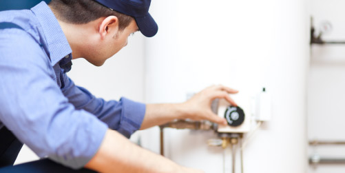 Photo of technician adjusting dial on water heater