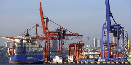 Photo of docked ship unloading containers.