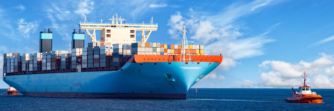 Photo of tugboat pulling large container ship at sea.