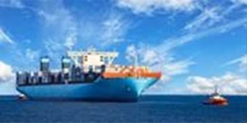 Photo of tugboat pulling large container ship at sea.