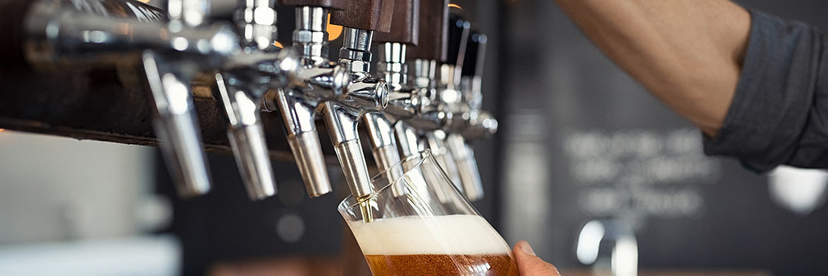 Header photo of taps pouring beer into glass