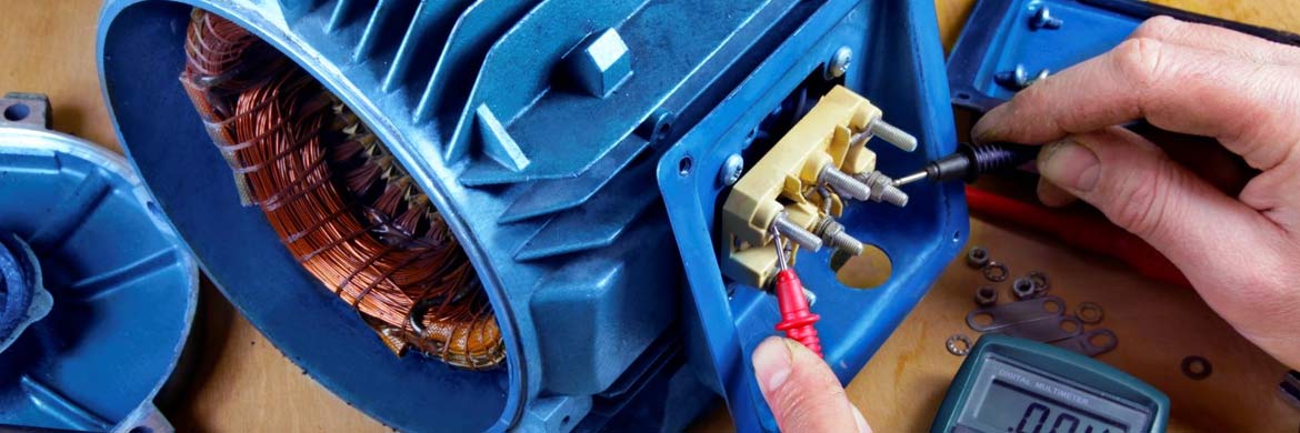 Photo of open blue electric motor with hands attaching diagnostic tool.
