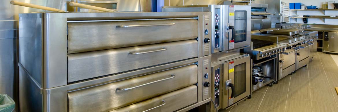 Interior of restaurant kitchen showing multiple commercial ovens.