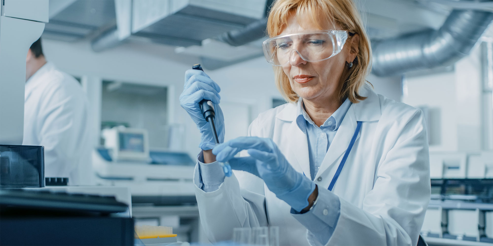 a woman scientist wearing gloves and goggles doing an experiment