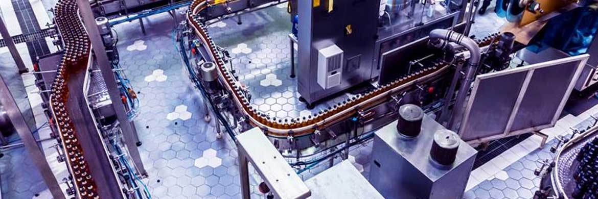 Overhead photo of bottles moving through beverage production conveyor line.