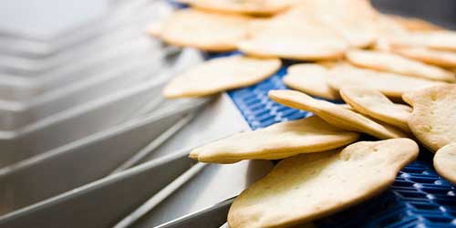 Photo of crackers on conveyor machine.
